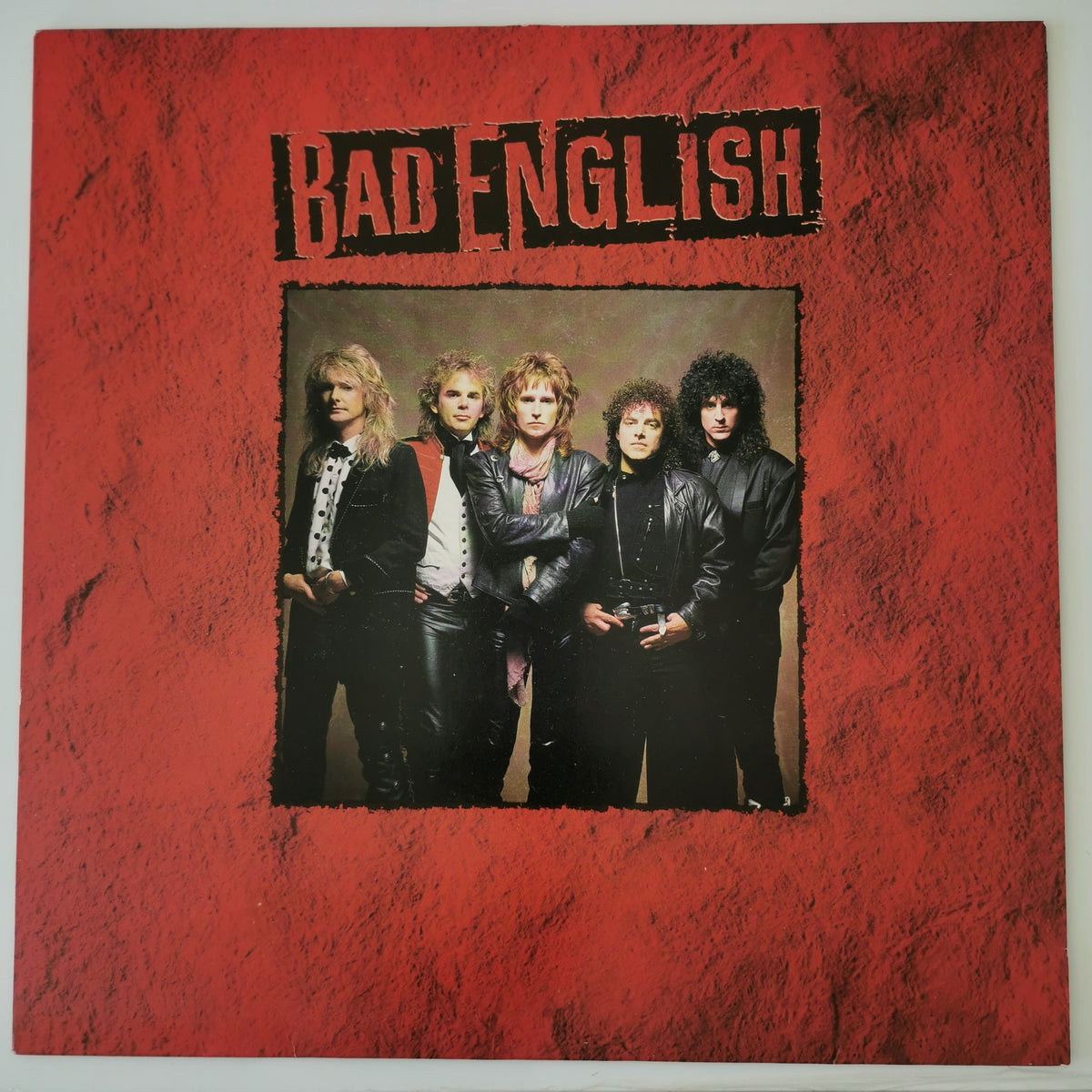 The album cover of Bad English's 'The Great Escape' vinyl record, featuring a textured red border with the band's name in black stencil lettering and a central photo of the five band members.