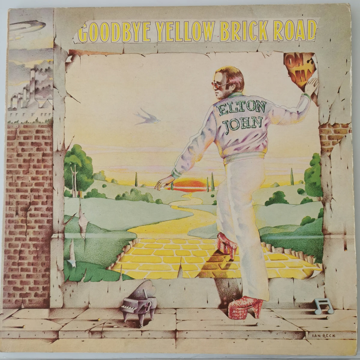 Elton John's 'Goodbye Yellow Brick Road' vinyl record album cover, featuring a surreal illustration of Elton John standing on a brick path with his back to the viewer, wearing a white jacket and pants. The album title is printed in yellow at the top.
