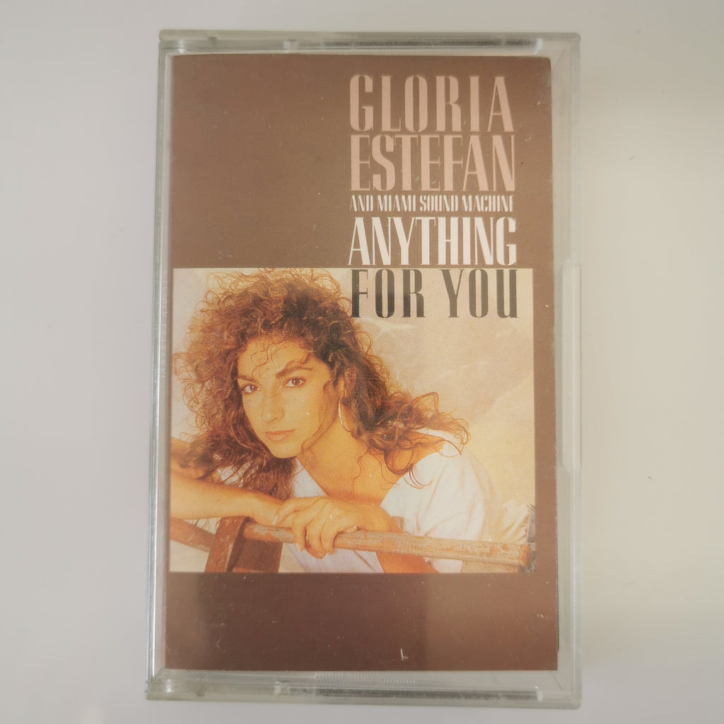 A vintage cassette tape of Gloria Estefan's 'Anything For You' in its clear plastic case, photographed against a plain light background.