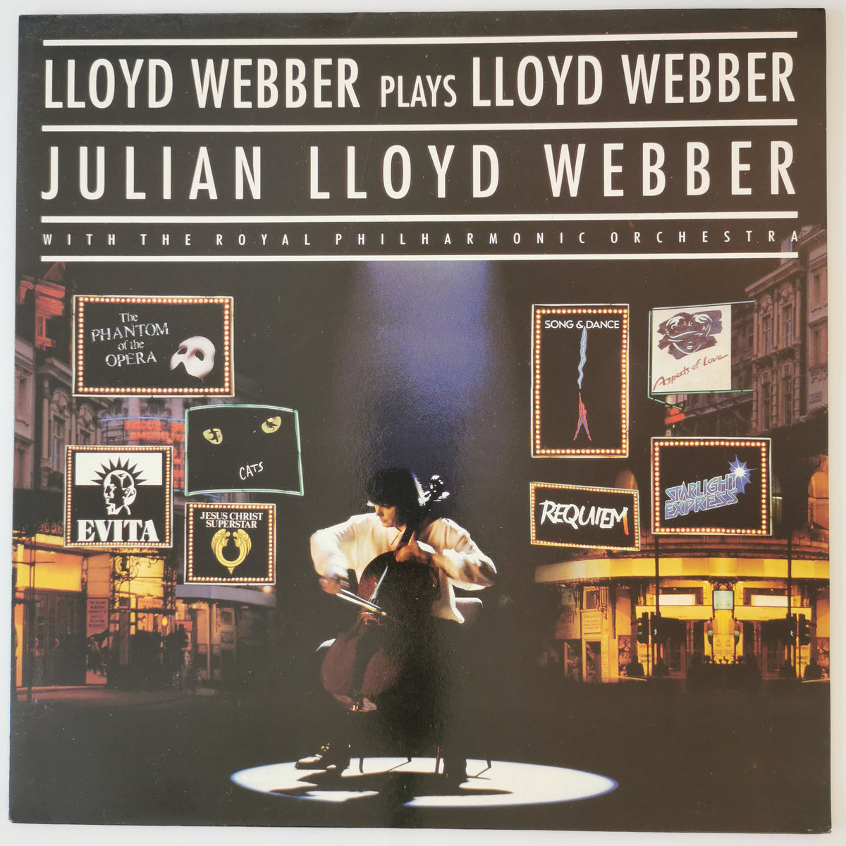 Album cover for 'Lloyd Webber Plays Lloyd Webber / Julian Lloyd Webber' featuring a cello player on stage surrounded by opera and music poster graphics, with the Royal Philharmonic Orchestra.