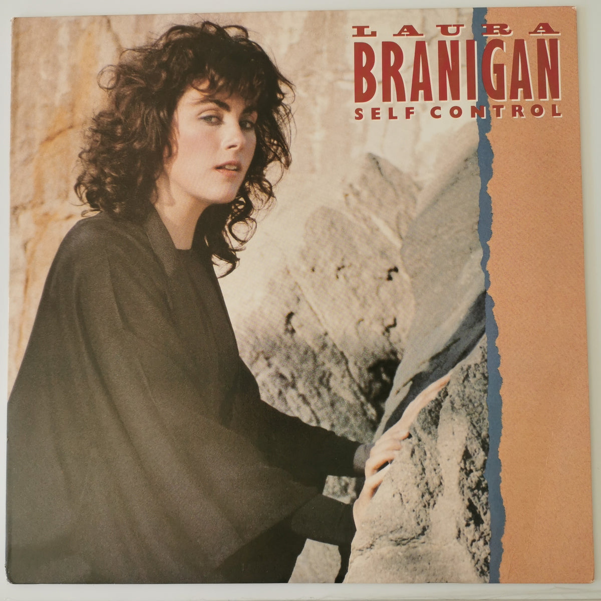 Vinyl record album cover for Laura Branigan's 'Self Control', featuring a portrait of the artist on the left and the title on the right, with a torn-paper effect separating a peach-colored section from a blue-toned photo of rocks.