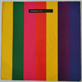 A square album or book cover featuring bold vertical stripes in yellow, green, pink, red, orange, purple, and blue, with a small black label near the top reading 'INTROSPECTIVE/FT SHOP BOYS'.