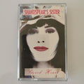 A cassette tape of Shakespeare's Sister's 'Sacred Heart' album, housed in a clear plastic protective case, photographed against a neutral light gray background.