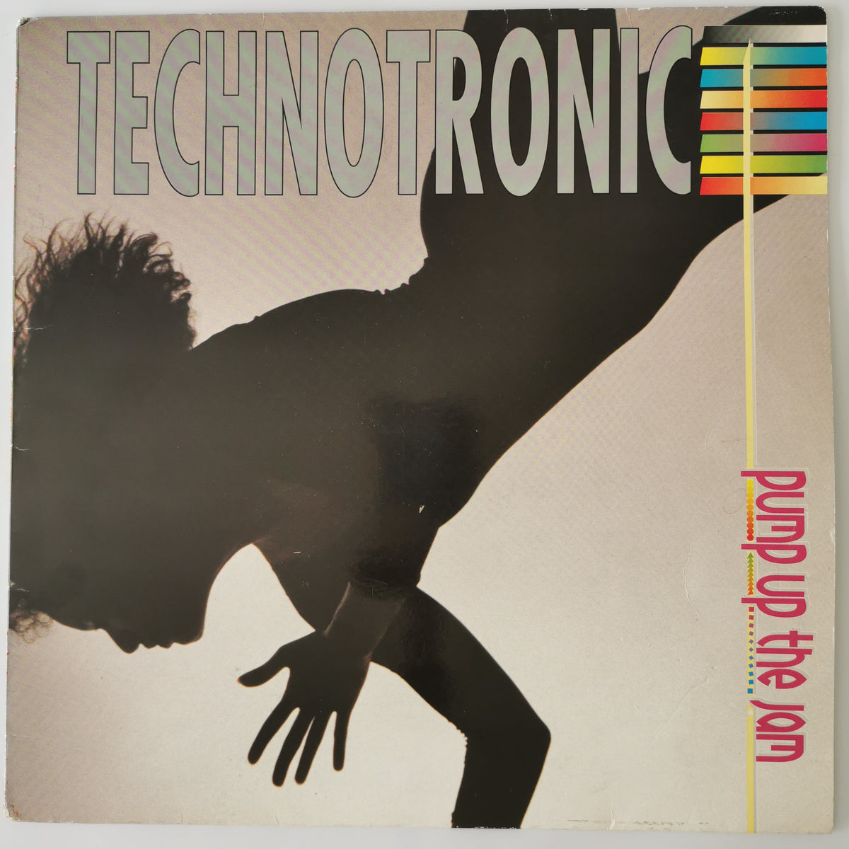 Vinyl record cover for Technotronic's 'Pump up the jam', featuring a large black silhouette of a person against a warm beige background with bold title text and a colorful striped graphic.