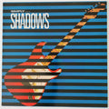 Vinyl record cover for Simply Shadows, featuring a red and white electric guitar overlaid with black and blue horizontal stripes against a blue striped background.