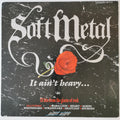 A square album cover for 'Soft Metal' with a distressed black marble background, large white gothic title text, a red rose in the center, and smaller red and white track/promoter text at the bottom.